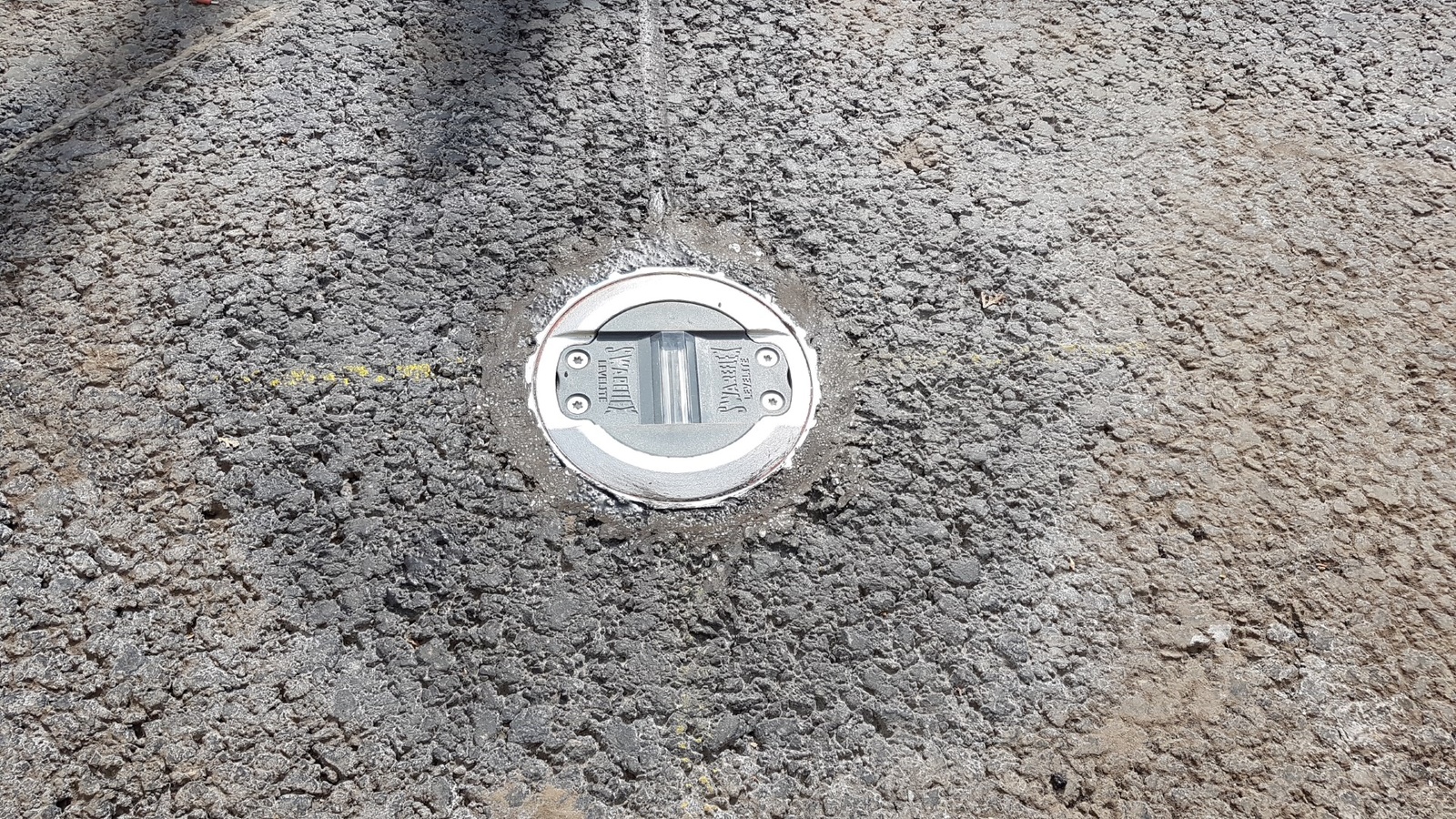 Detail bezpečnostného prvku osadeného vo vozovke pri priechode pre chodcov.